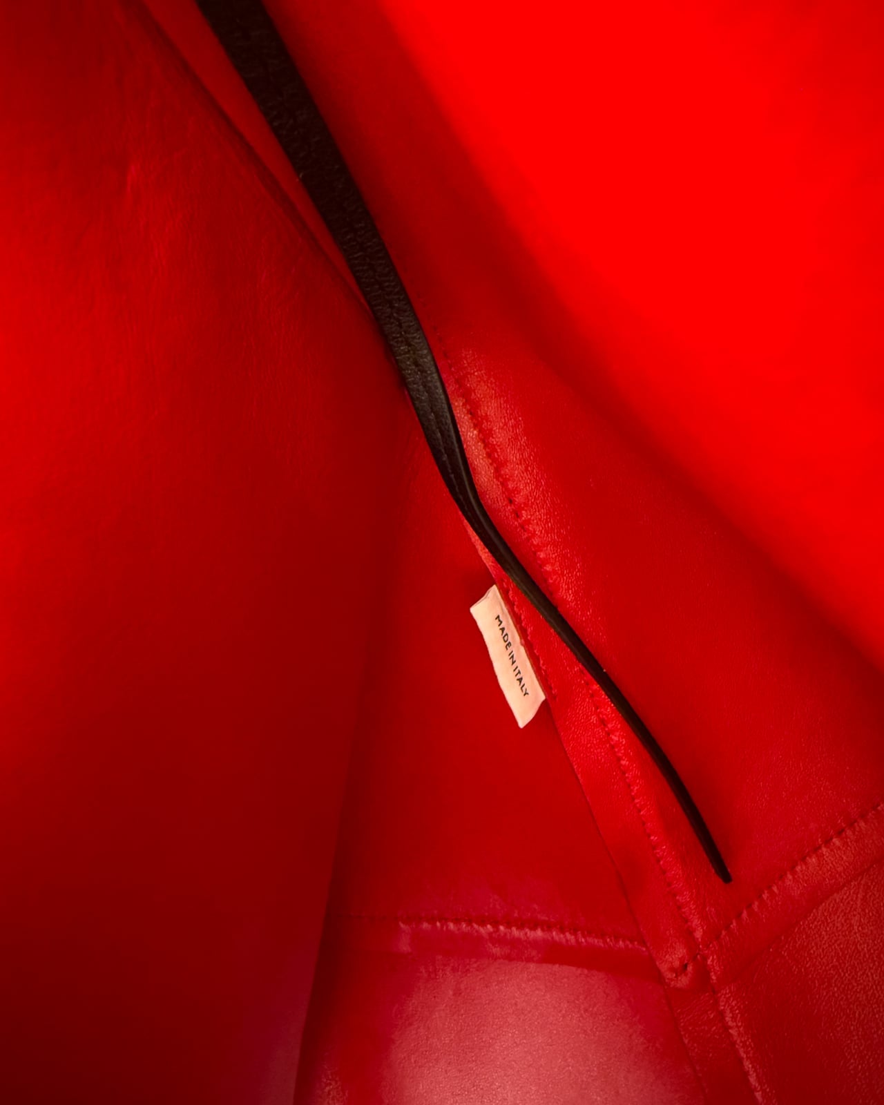Made in Italy label stitched into the red lambskin lining of the tote - Luxe Digital