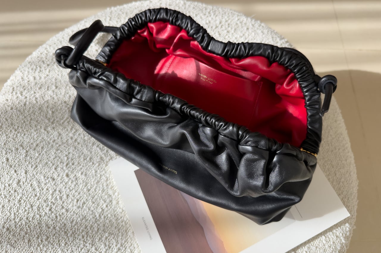 Mansur Gavriel Oversized Cloud opened to show the red interior of the black clutch - Luxe Digital