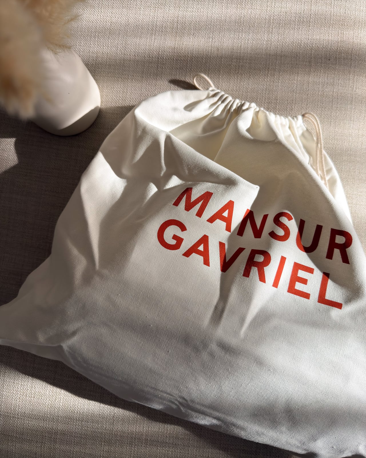 Mansur Gavriel dust bag printed with the brand name in red - Luxe Digital
