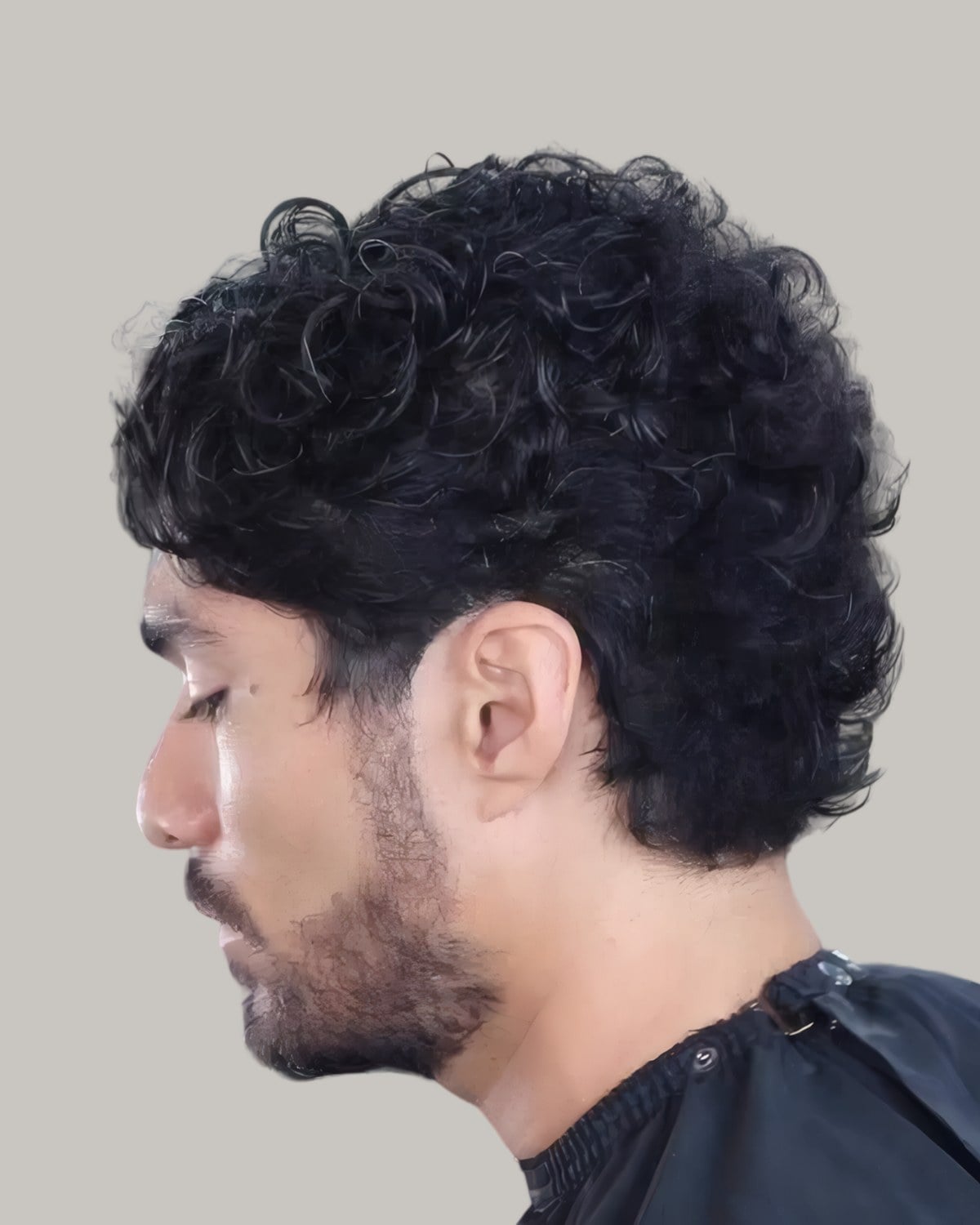 Man with a full curly top and a beard, seen from the side