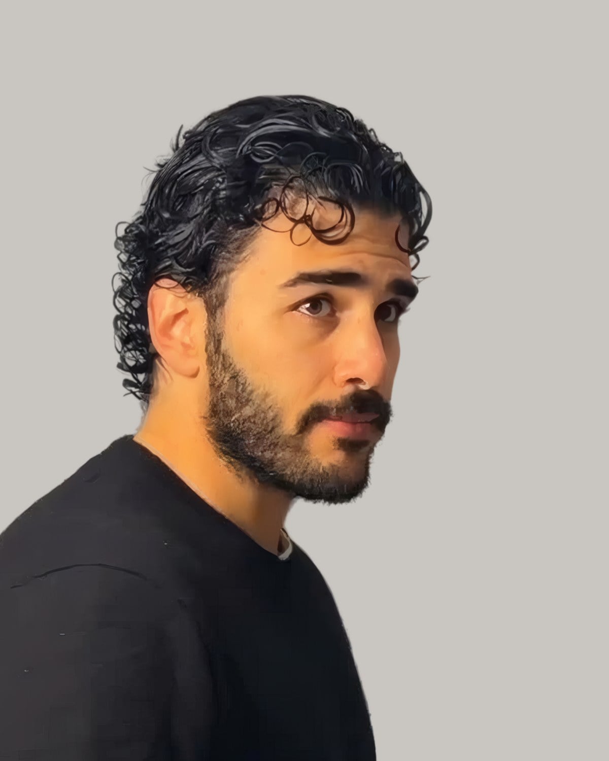 Bearded man with curls slicked back, seen in profile