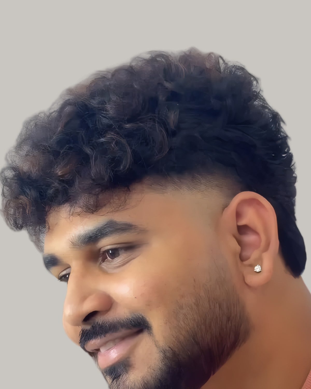 Smiling bearded man with curls and a fade, seen from the side