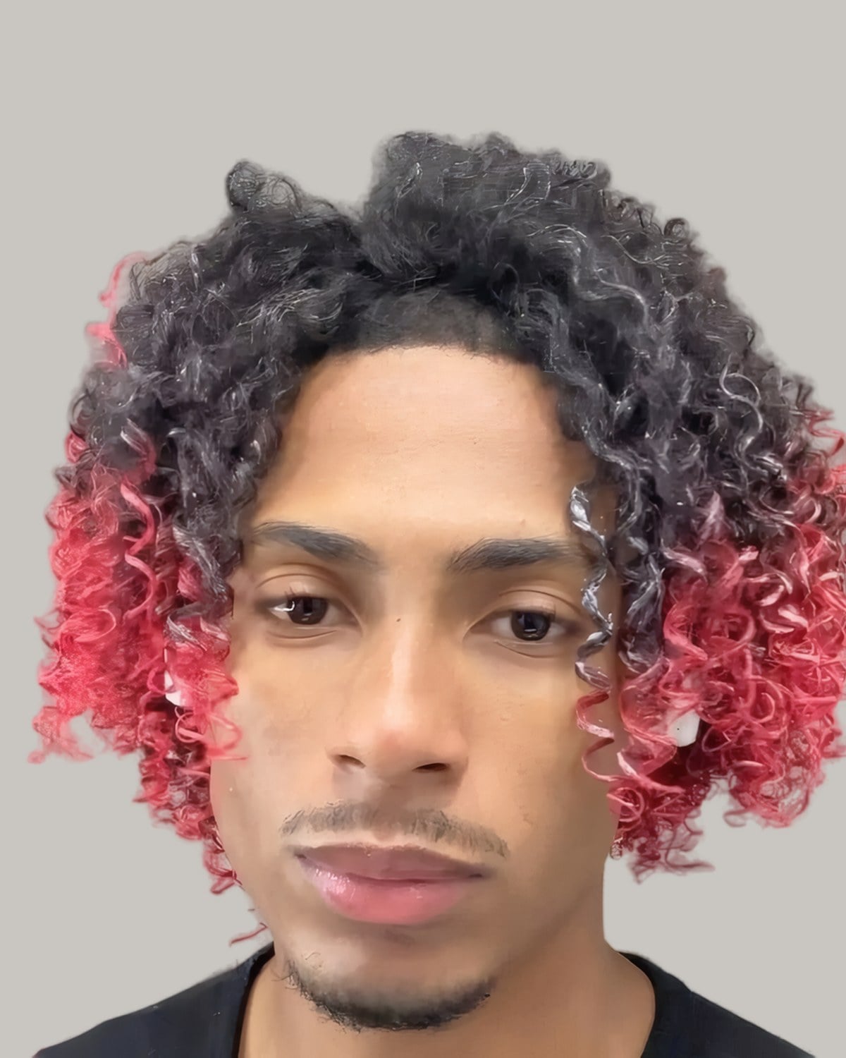 Young man with curls dyed red at the ends, seen from the front