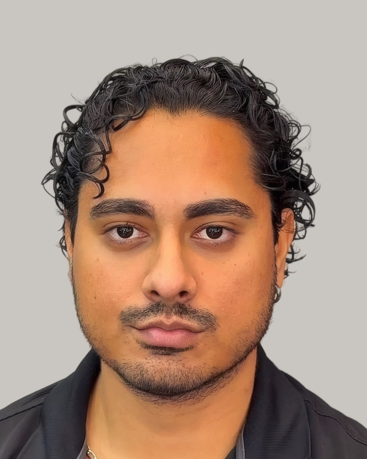 Man with shoulder-length curls and a mustache, seen from the front