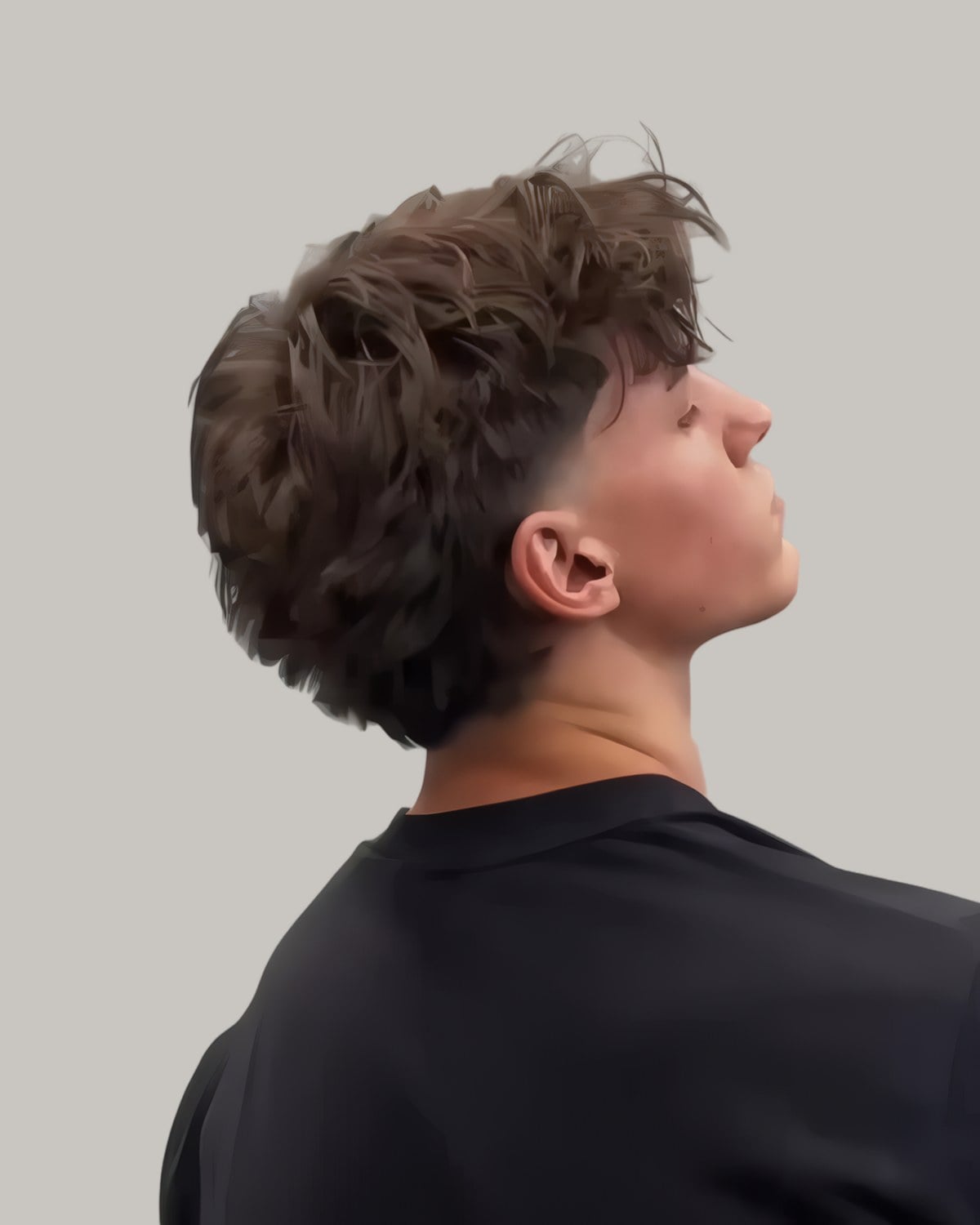 Young man with a full curly top and a taper, seen in profile