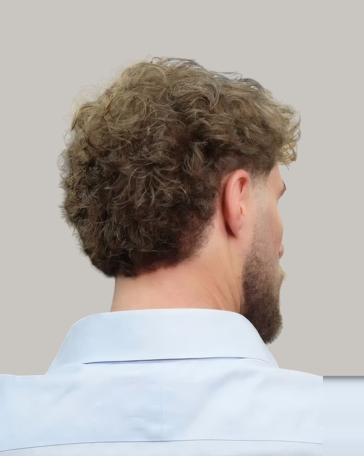 Bearded man with light-brown highlighted curls, seen from behind at an angle