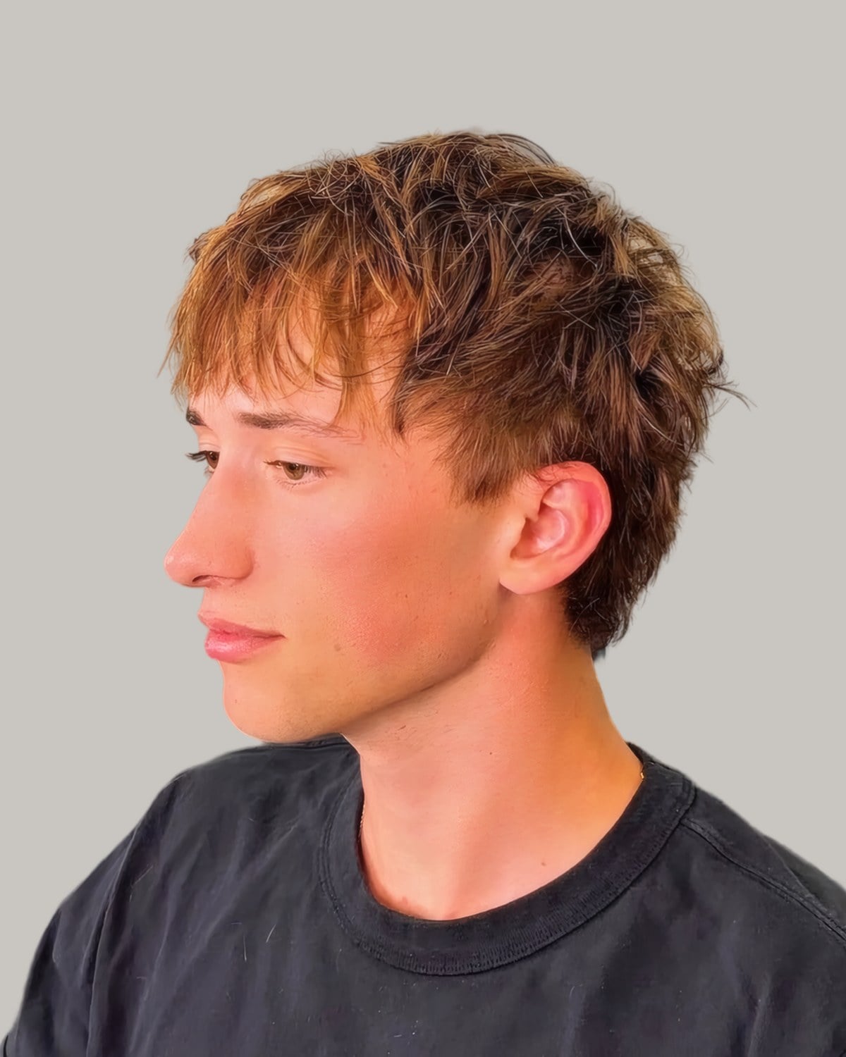 Young man with copper-dyed hair, seen from the side