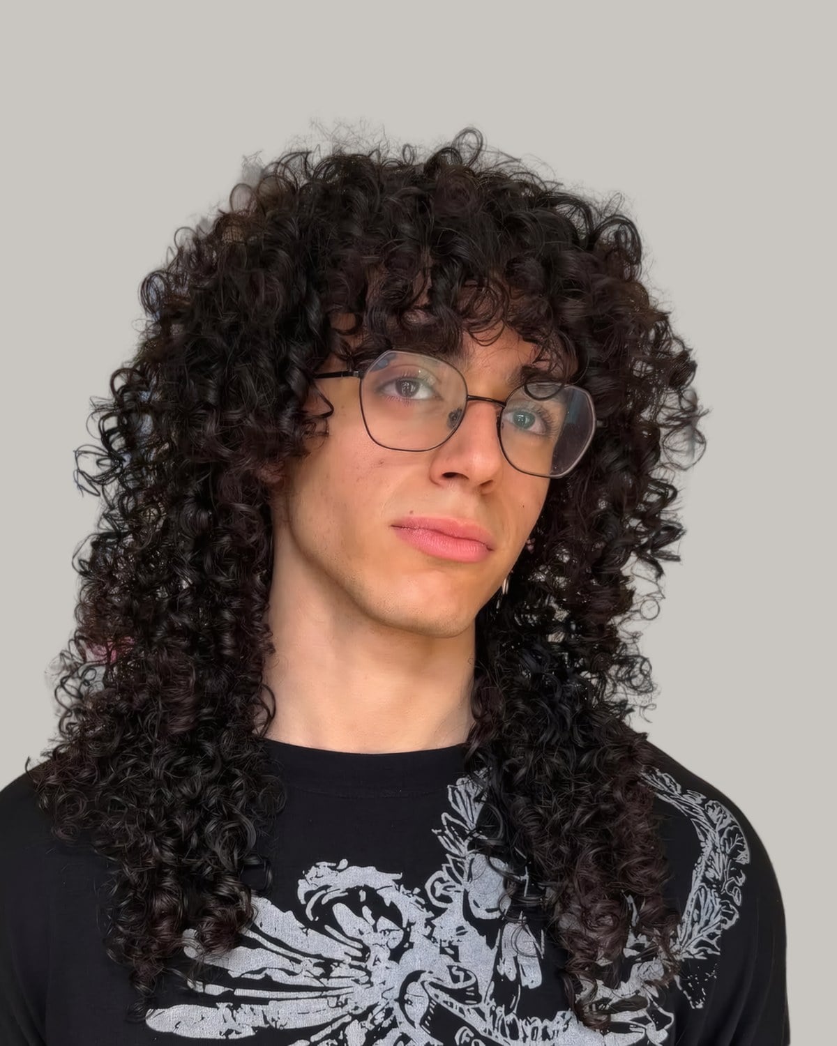 Man with glasses and long ringlets with a fringe, seen from the front