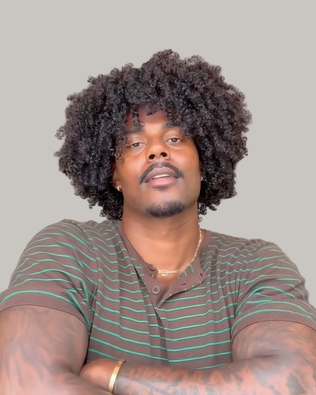 Man with a full afro and a striped T-shirt, seen from the front