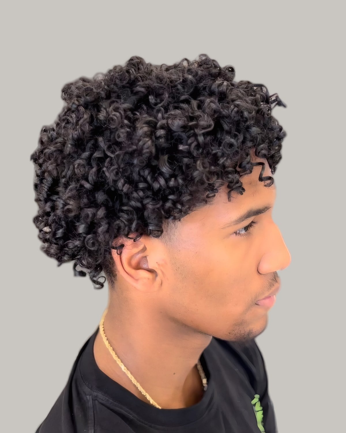 Young man with short tight curls, seen from the side