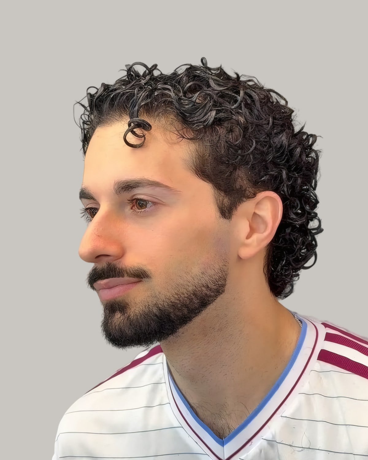 Man with short curls and a beard, seen from the side