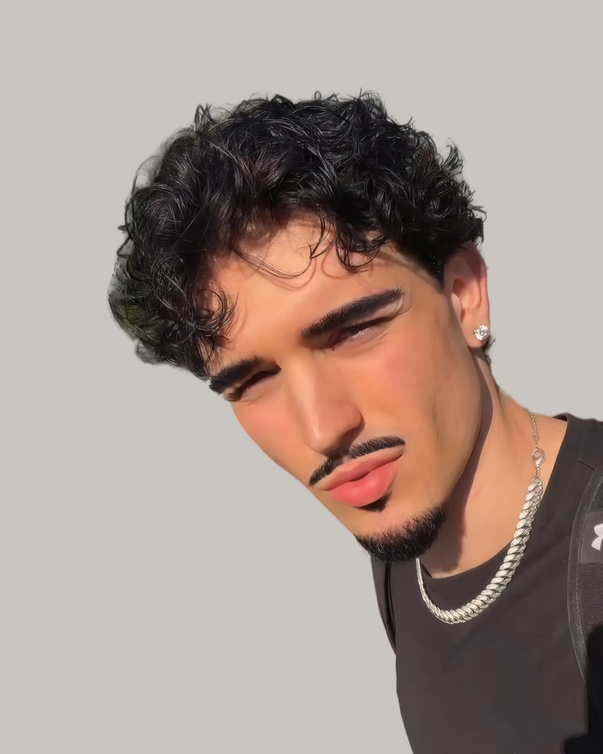 Man with a long curly top and a taper, seen from the side at an angle