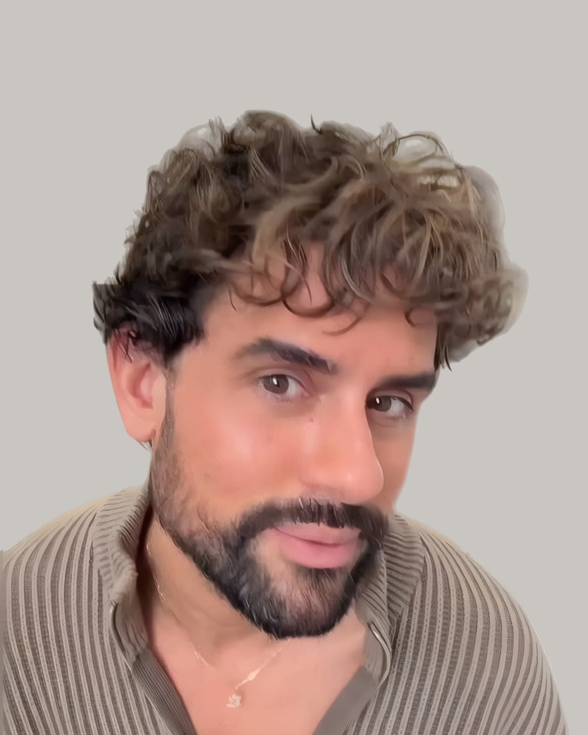 Bearded man in a ribbed sweater with short brown curls brushed up from a side part