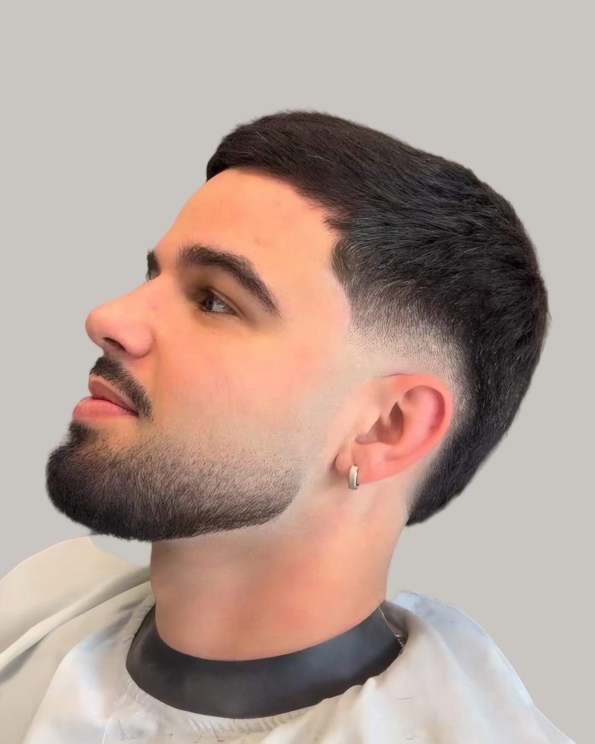 Bearded man with a short dark crop and a mid fade, seen in profile