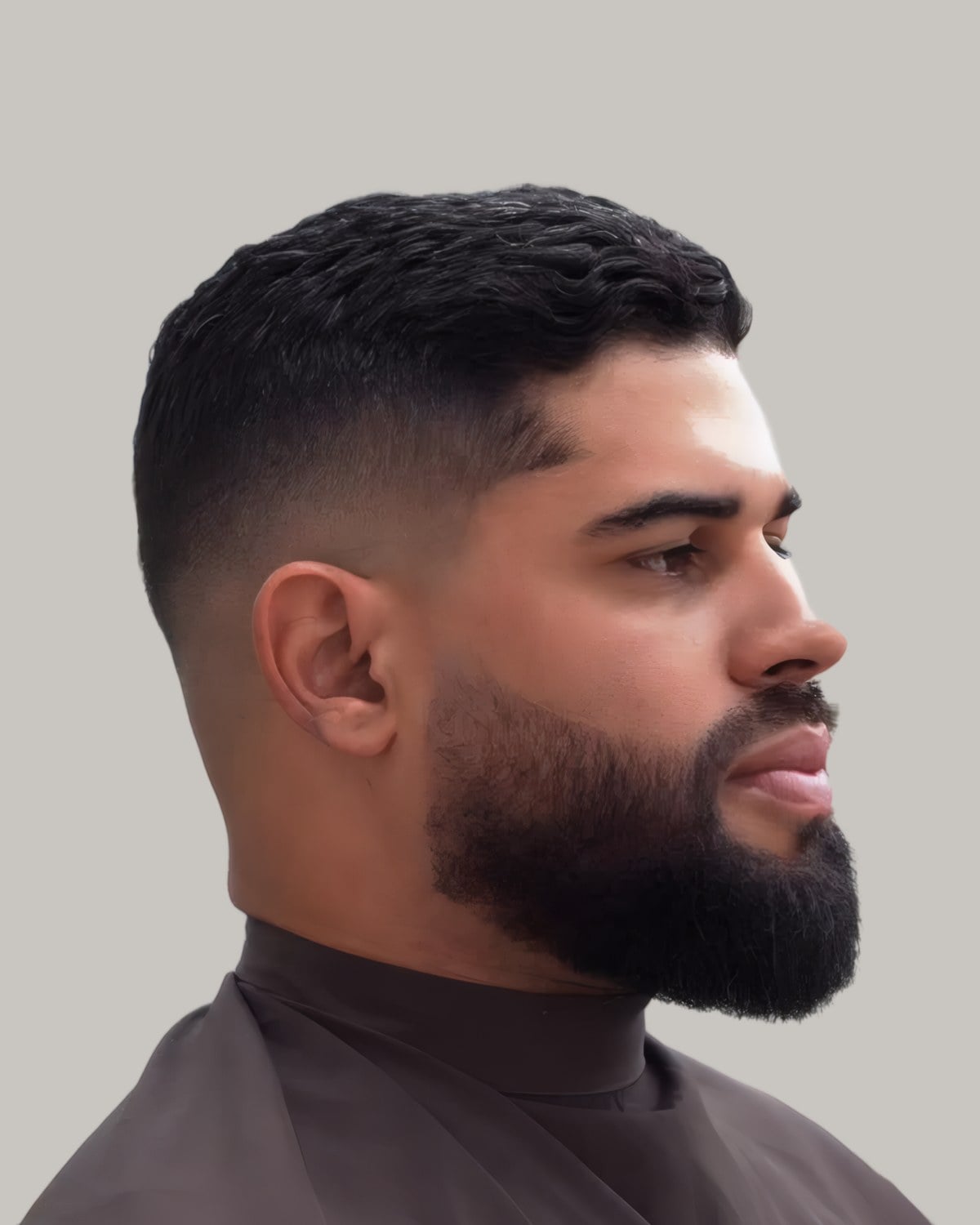 Man with a full beard, a short crop and a skin fade, seen at an angle