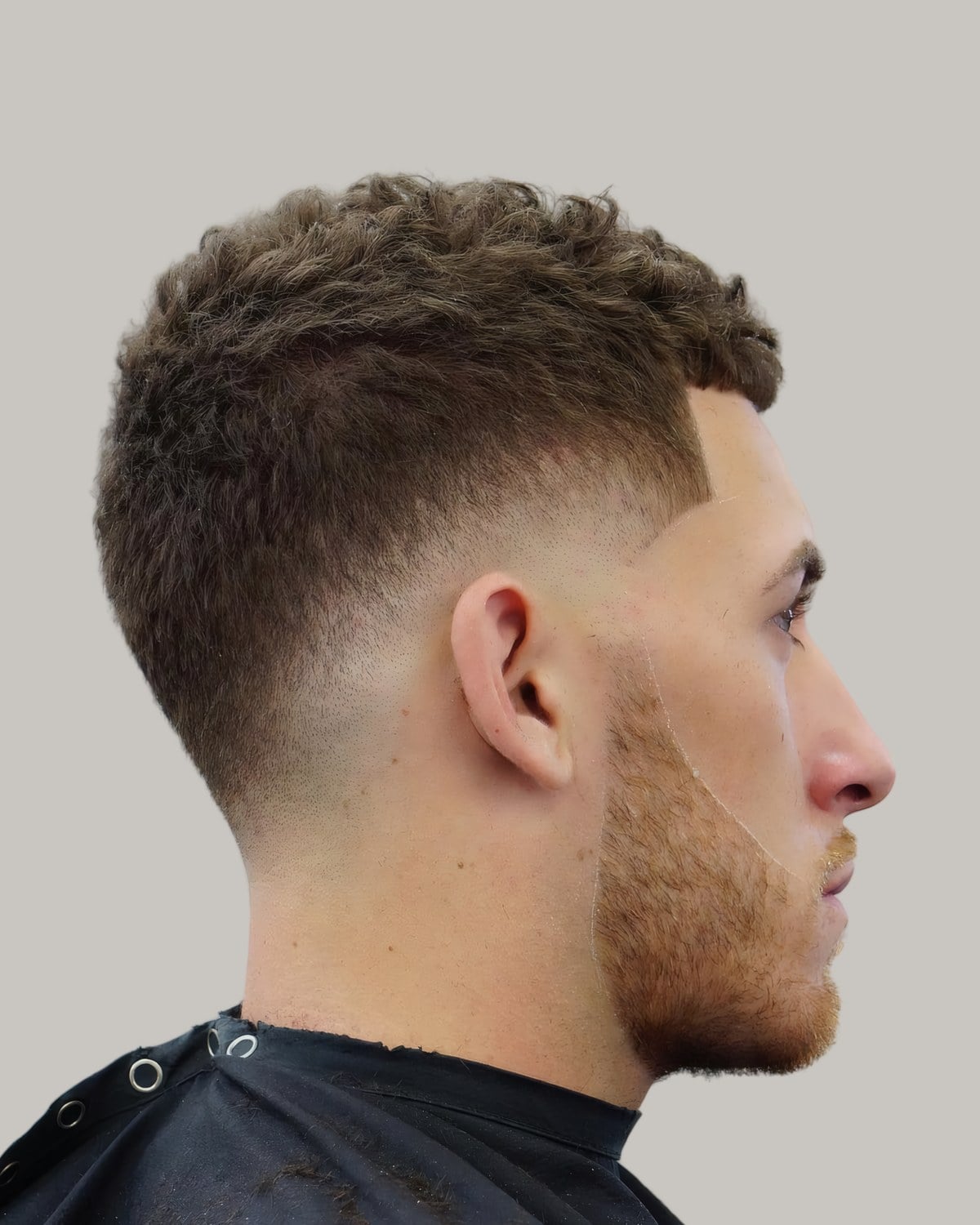 Bearded man with a short textured crop and a drop fade, seen in profile