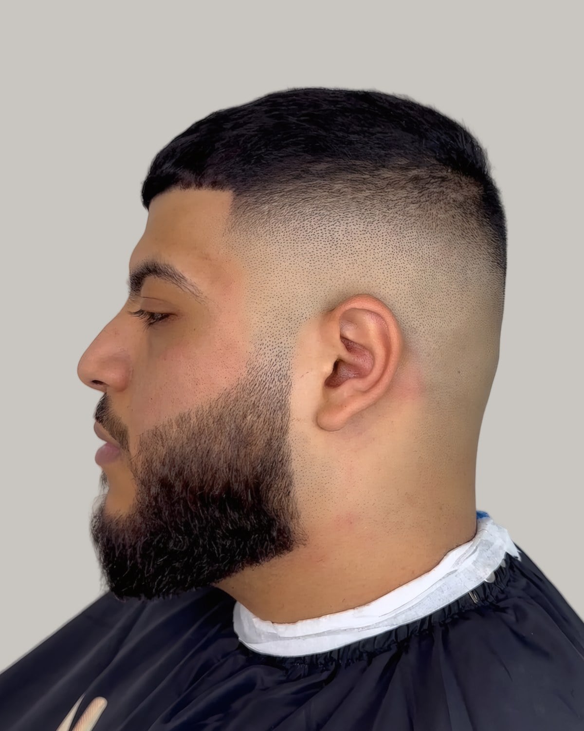 Bearded man with a short crop and a high skin fade, seen in profile