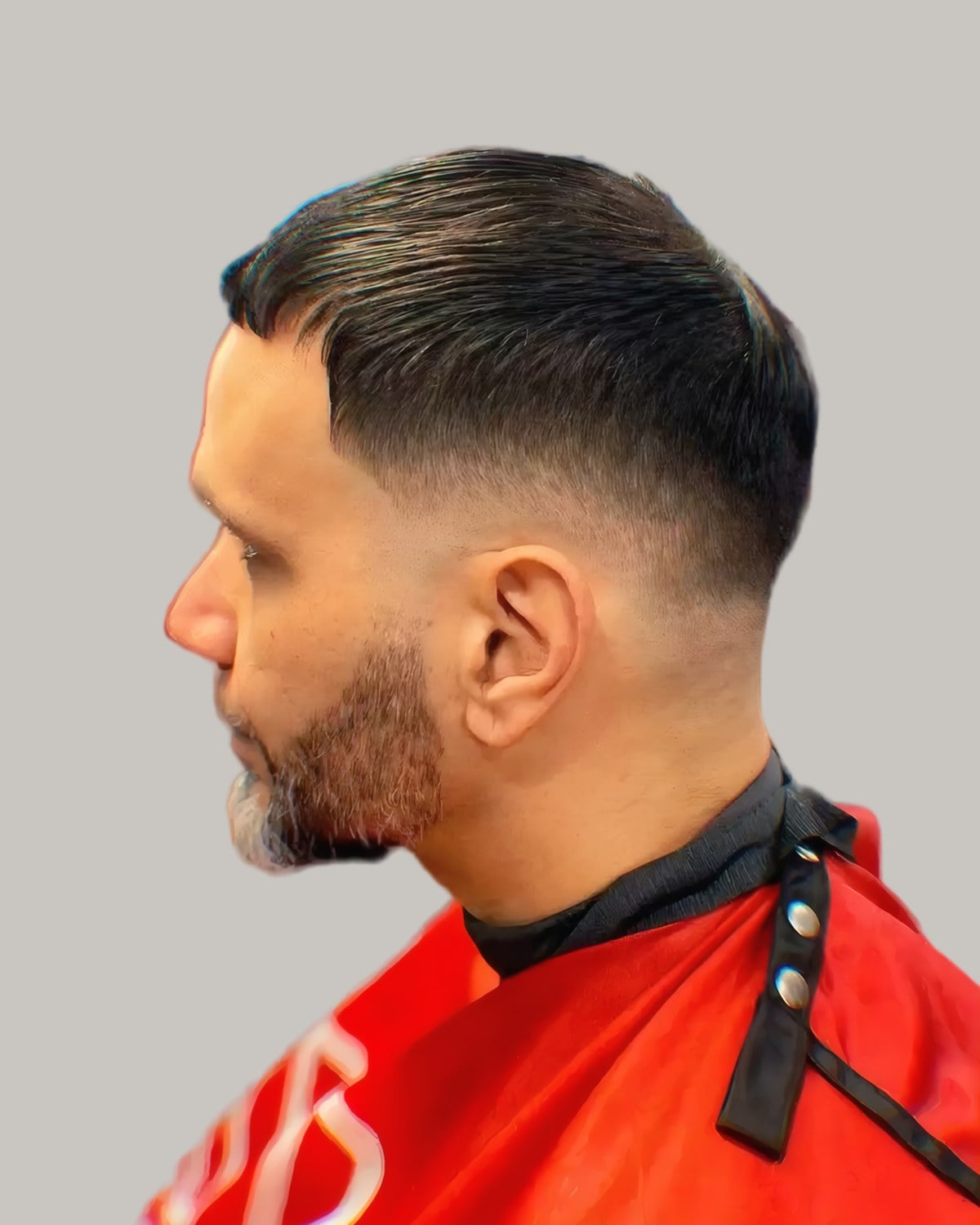Bearded man with slicked-back hair and a mid fade, seen in profile