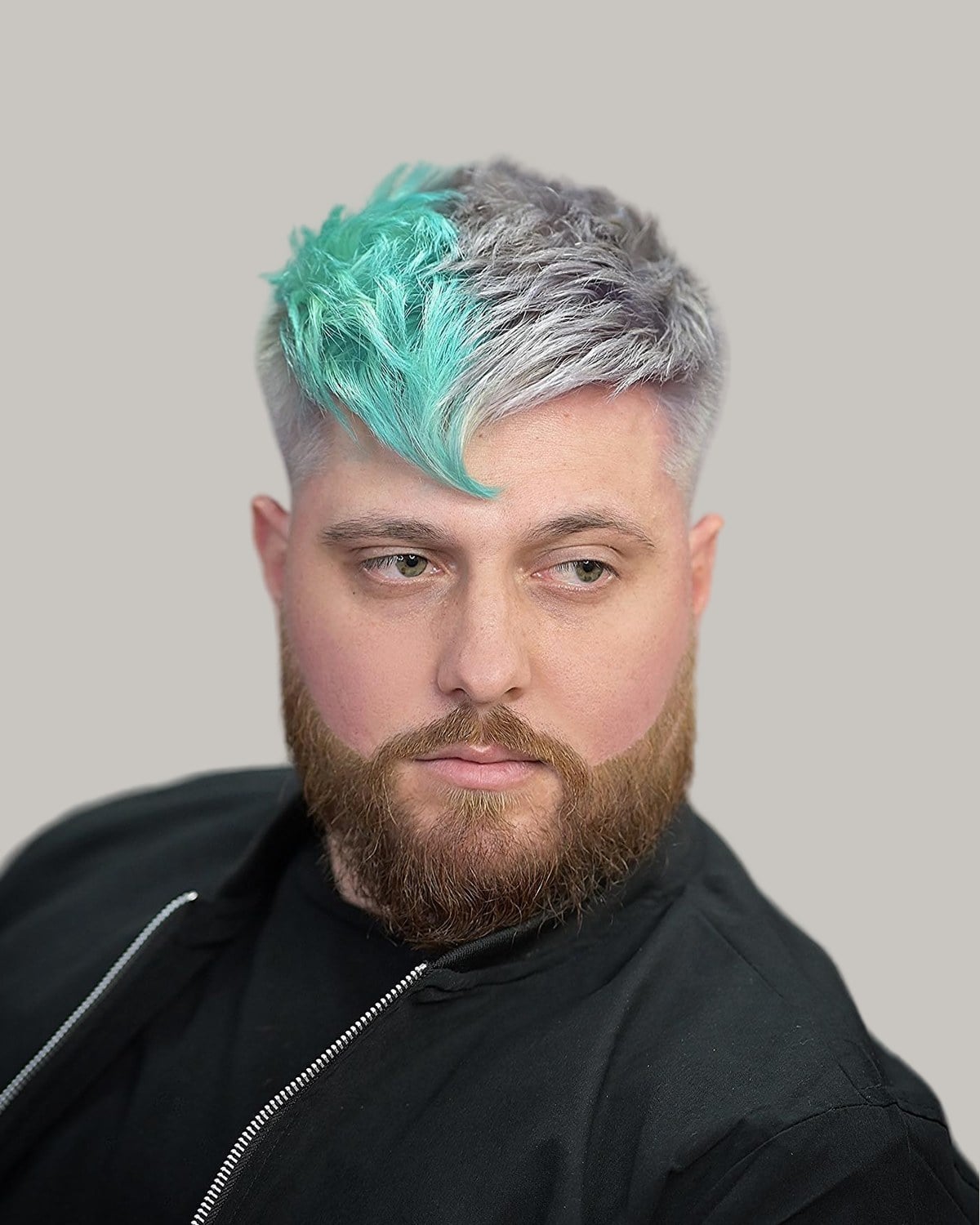 Bearded man with a silver crop and a mint-green fringe swept down across one side of his forehead