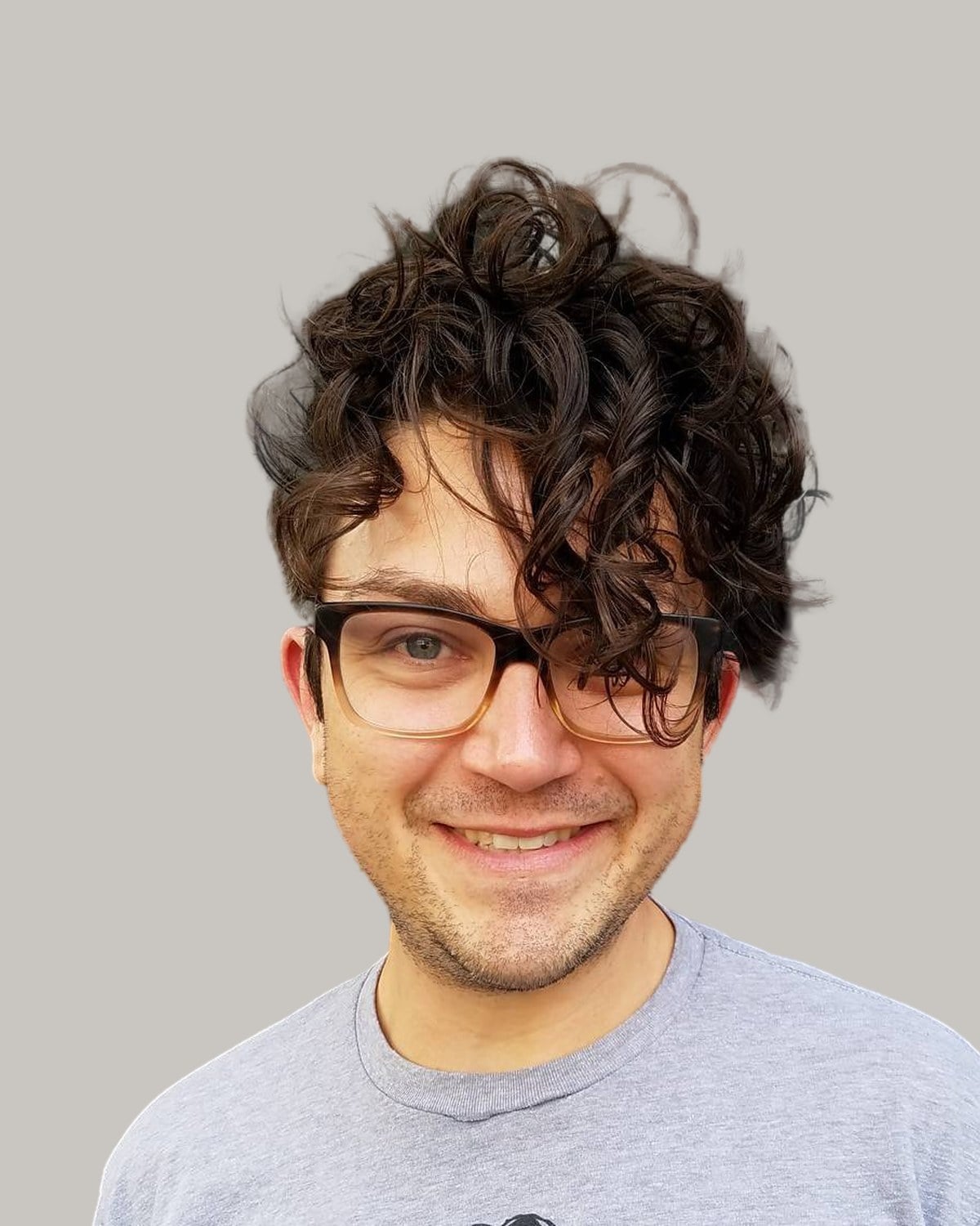 Smiling man with long, loose curls on top falling across his forehead, and dark-rimmed glasses