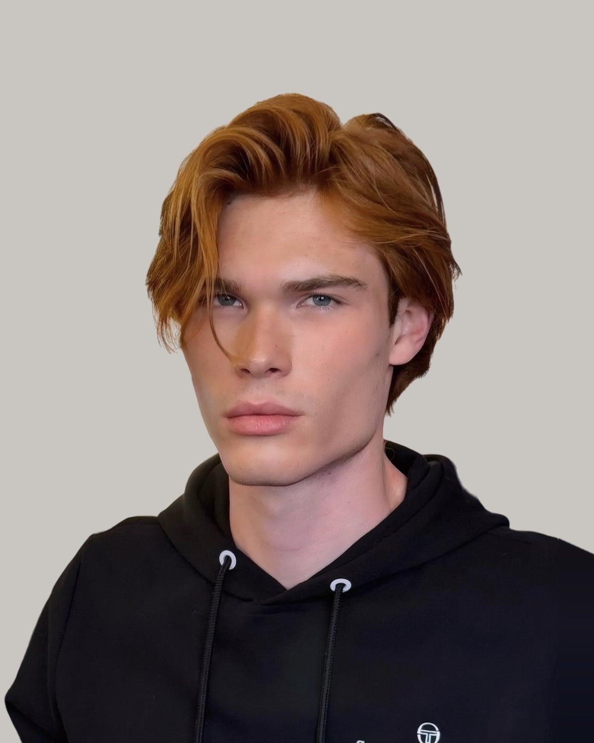 Young man with straight, copper-blond hair swept to one side past his ears