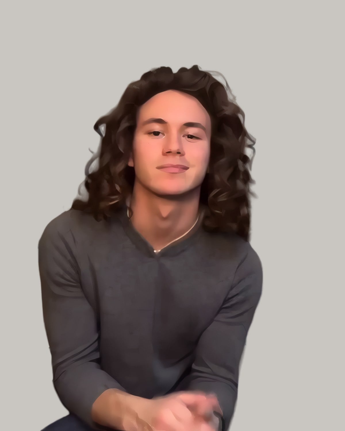 Smiling young man in a grey sweater with long curls falling past his shoulders, seated