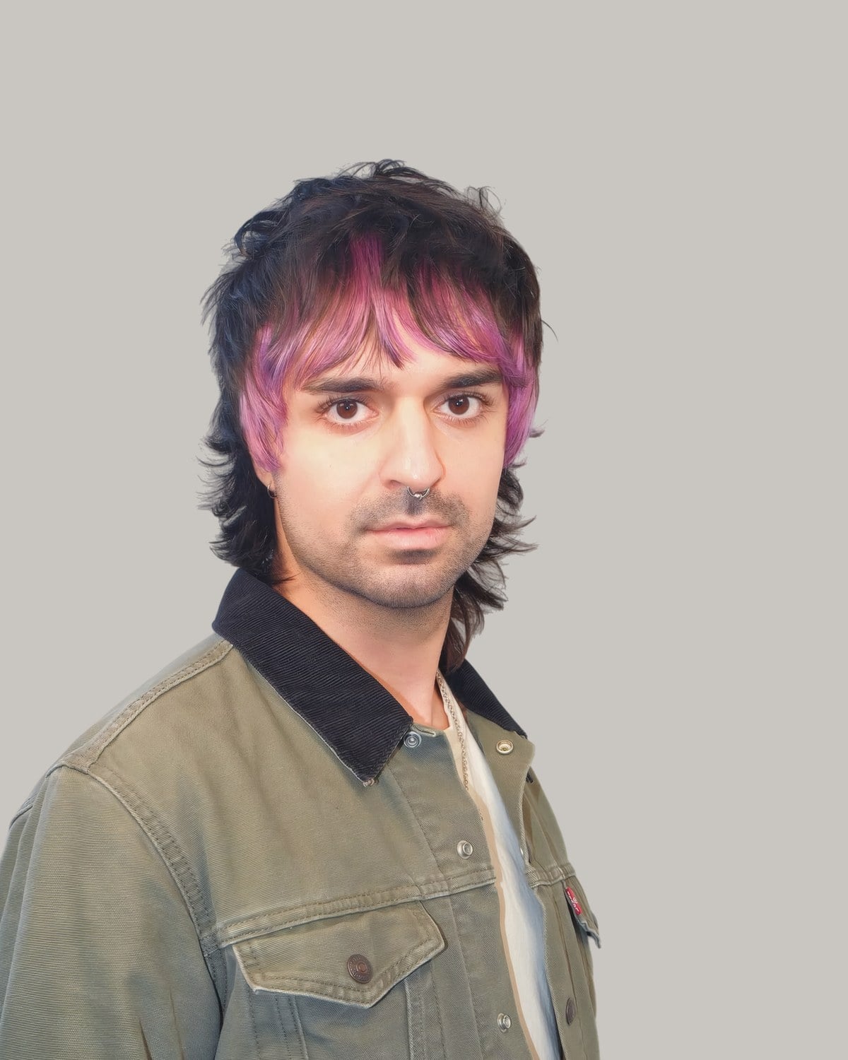 Man with a dark shag and a pink-streaked fringe, in a green jacket