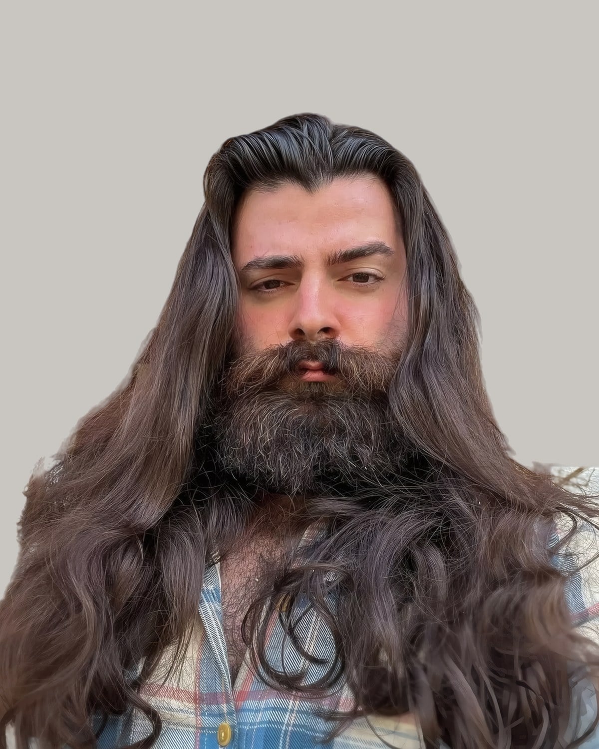 Bearded man with long, wavy dark hair swept back from a side part