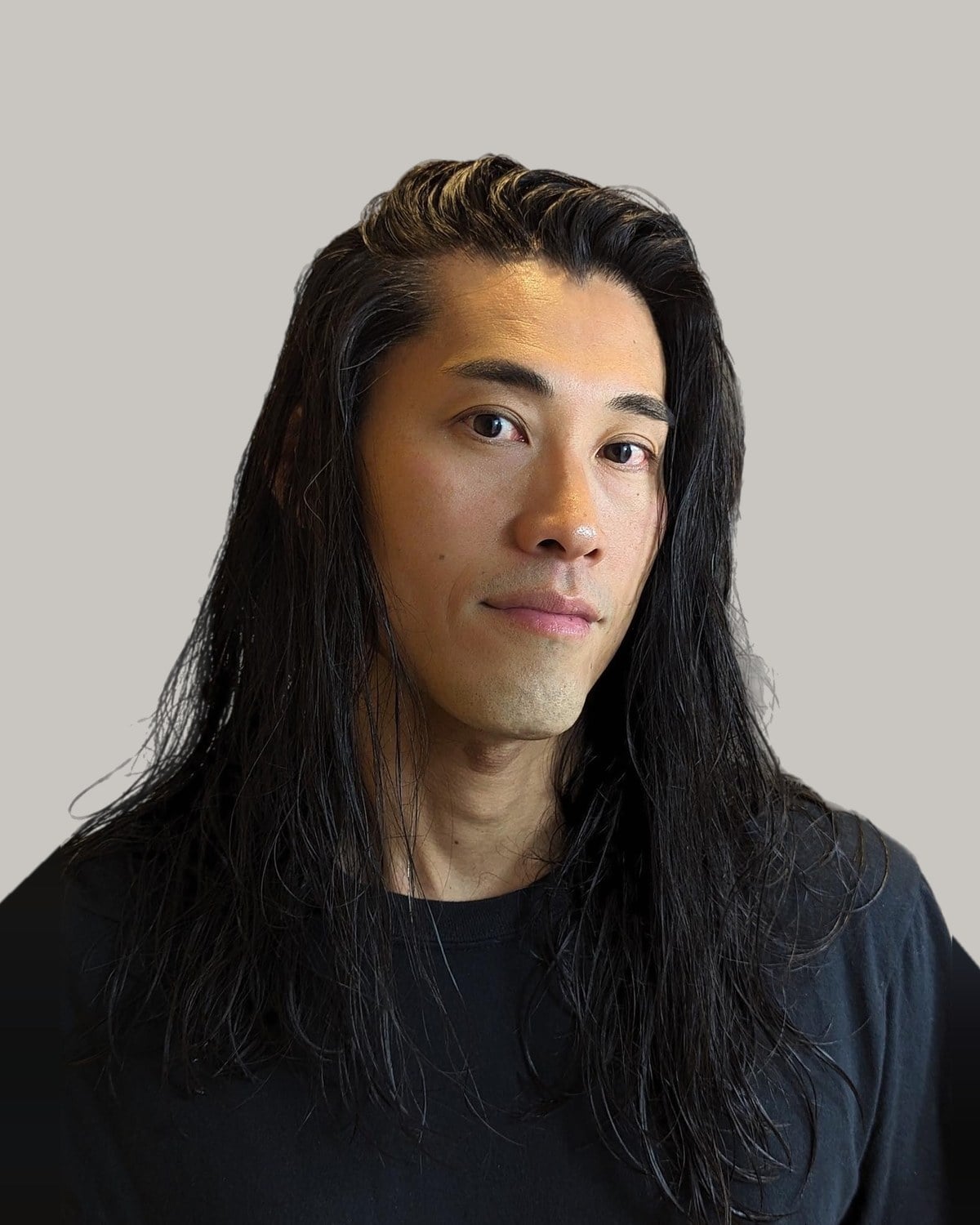 Man with long, straight black hair parted in the middle and falling past his shoulders