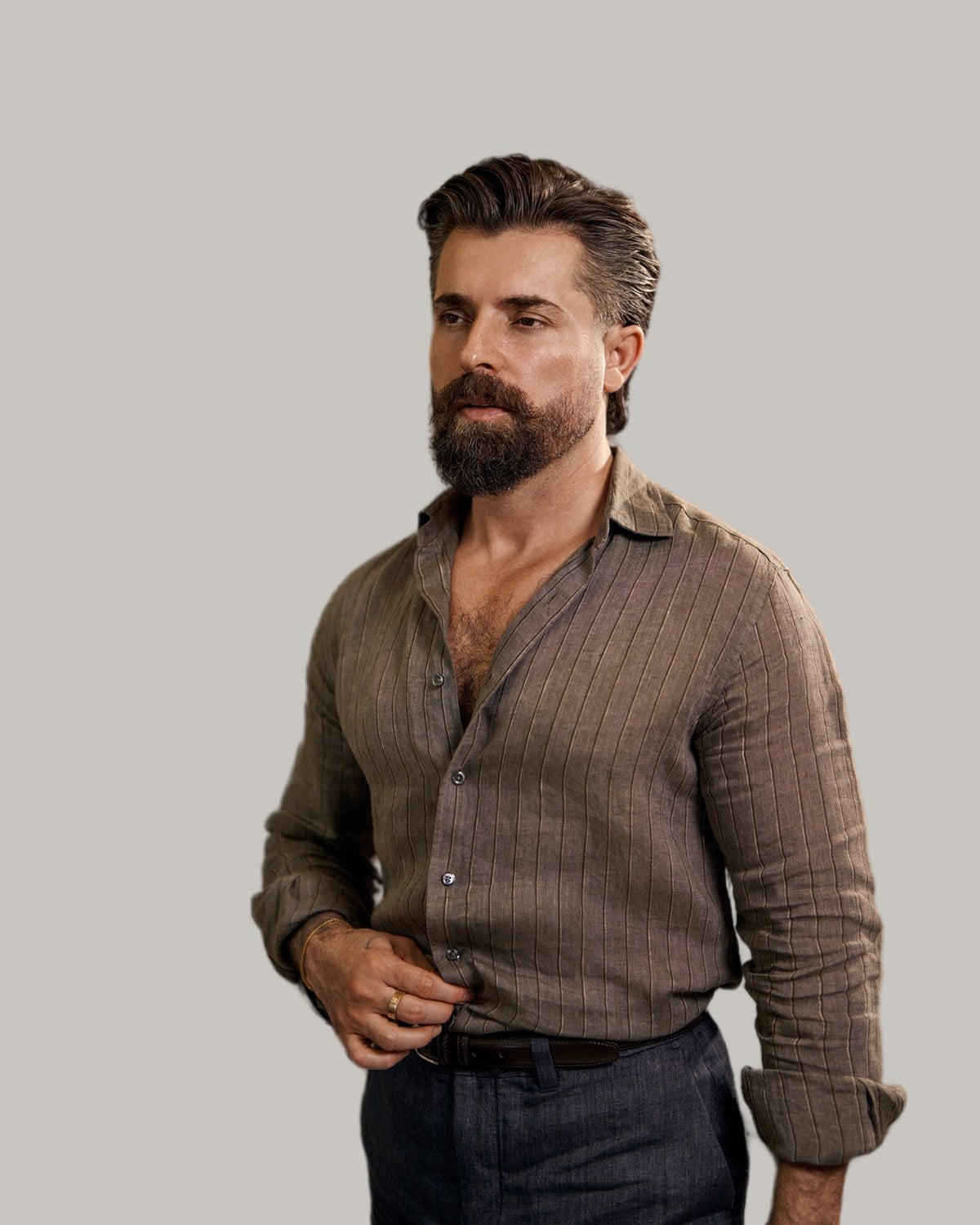 Bearded man in a linen shirt with his hair combed straight back