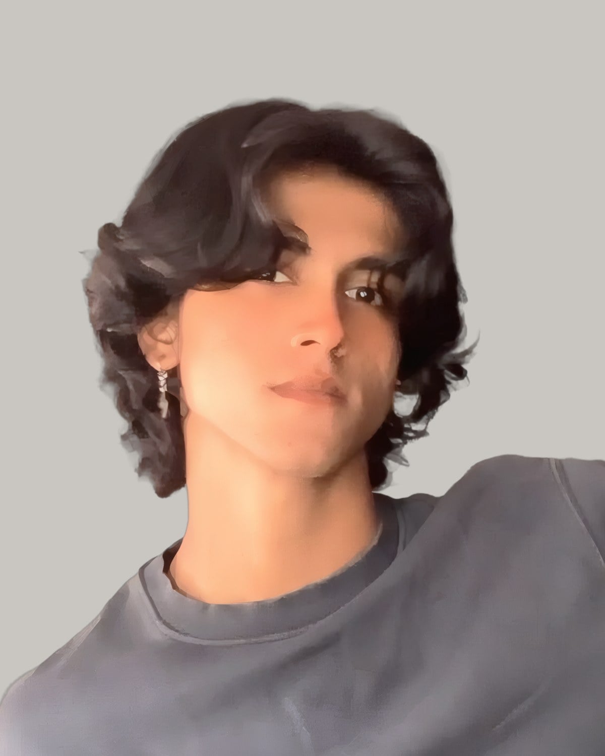 Young man with dark wavy hair parted in the middle and falling to his cheekbones, in a grey sweatshirt