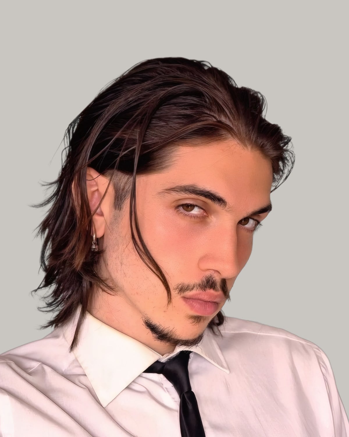 Young man in a white shirt and black tie with long dark hair pushed back to his shoulders