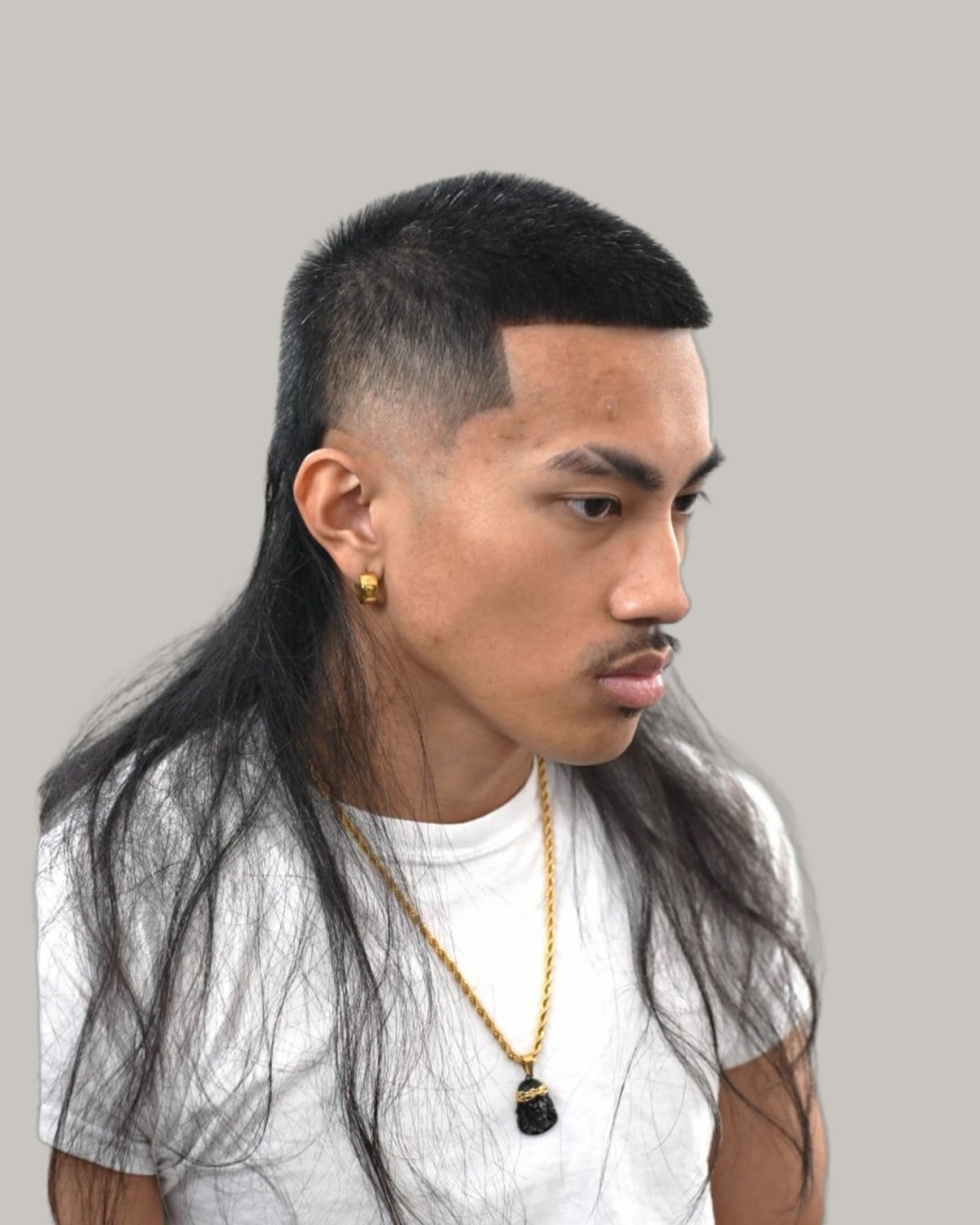 Man with a buzzed top, faded sides and long straight hair at the back