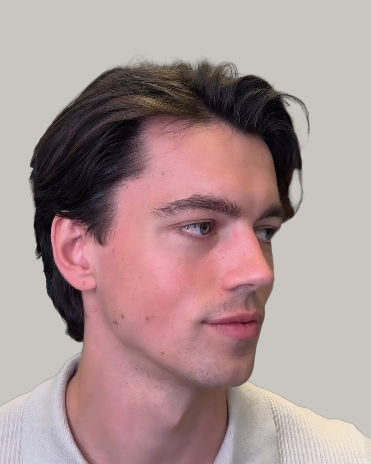 Man in a polo shirt with dark hair swept back from a side part