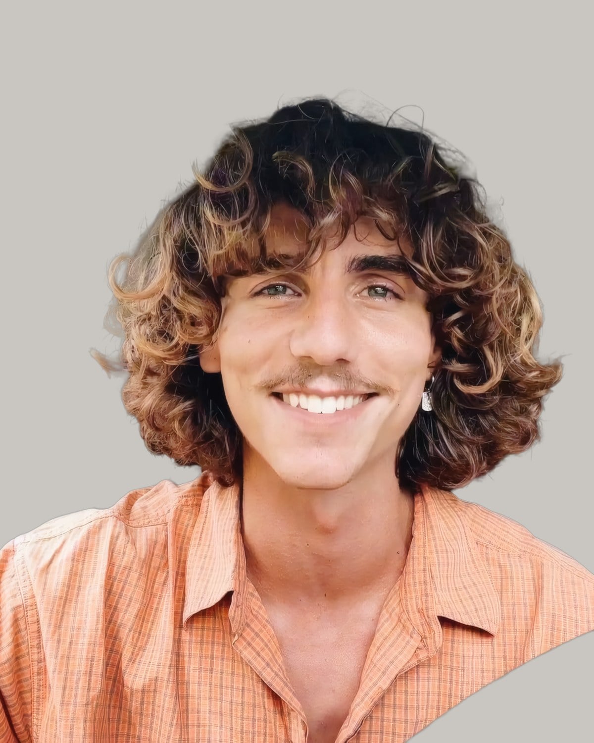Smiling man with a moustache and curly light brown hair falling to his shoulders
