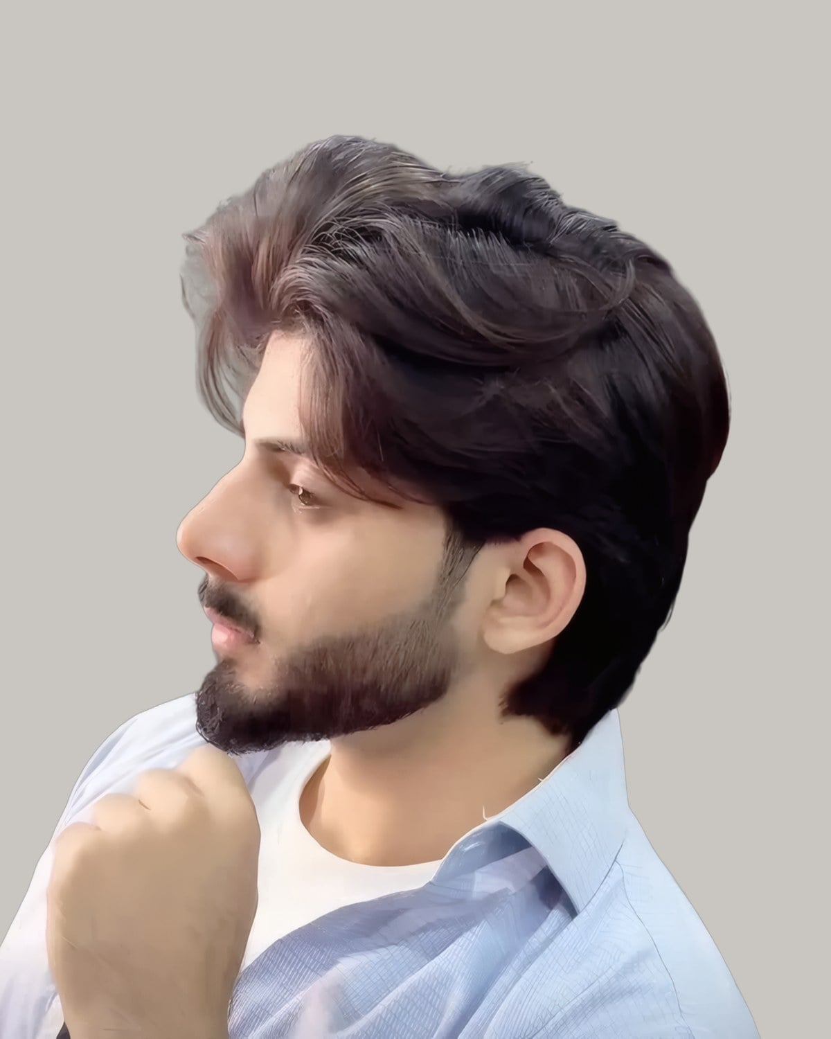Bearded man with dark hair swept back and up, one hand at his chin