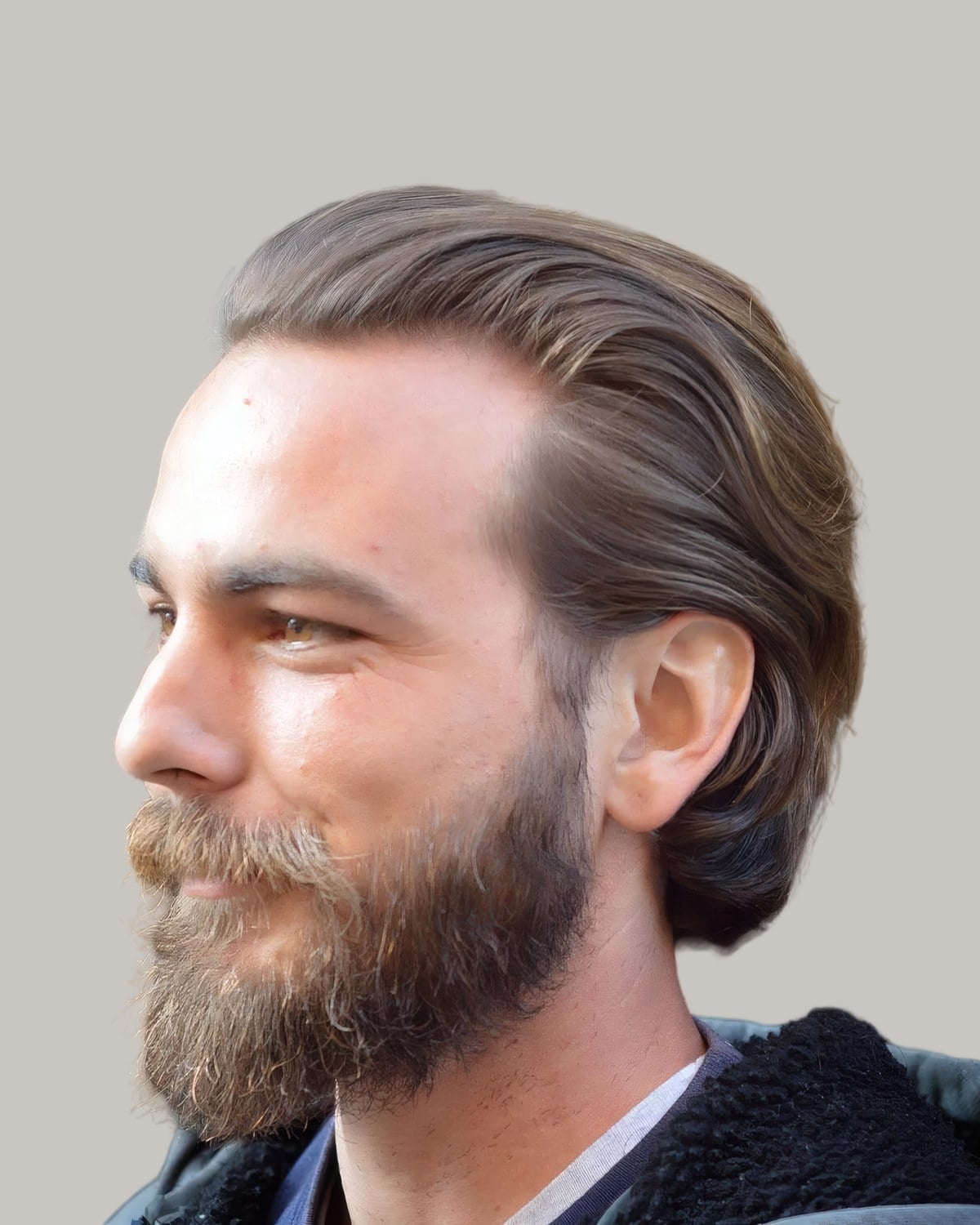 Bearded man with light brown, wavy hair combed back to the collar, seen from the side