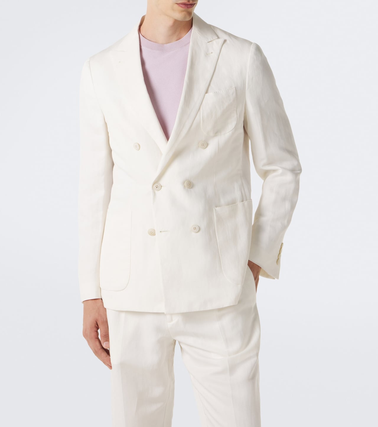 man in a white double-breasted linen and silk blazer with matching white trousers and a lilac T-shirt