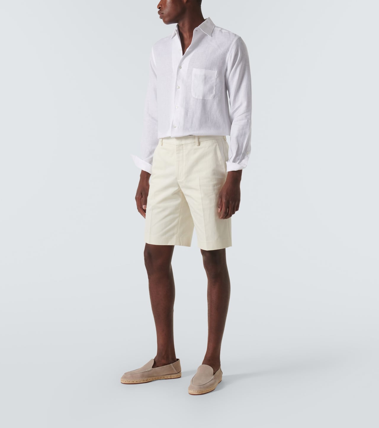 man in a white linen shirt with cream shorts and suede loafers