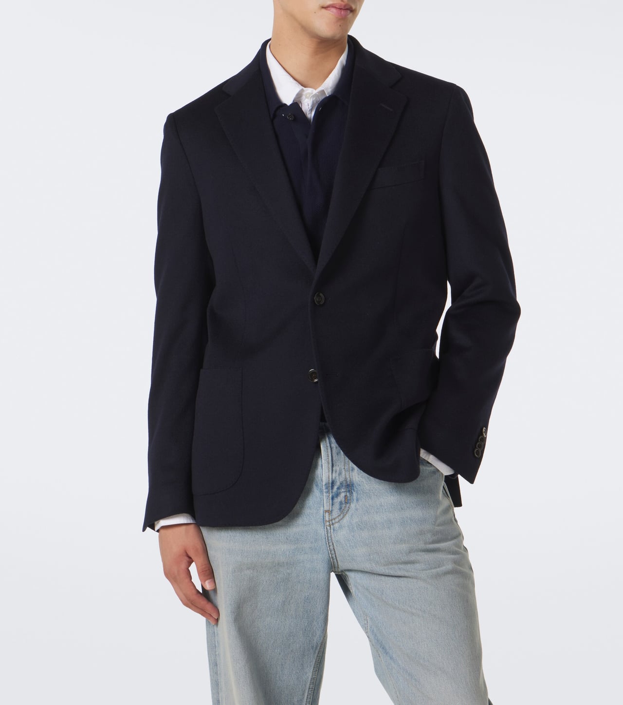 man in a navy cashmere blazer over a shirt with light blue jeans and loafers