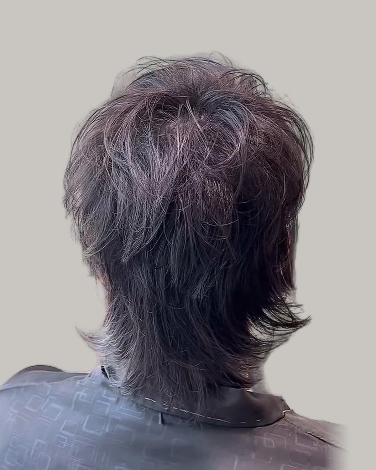 Wolf cut mullet with grey tones seen from behind at an angle