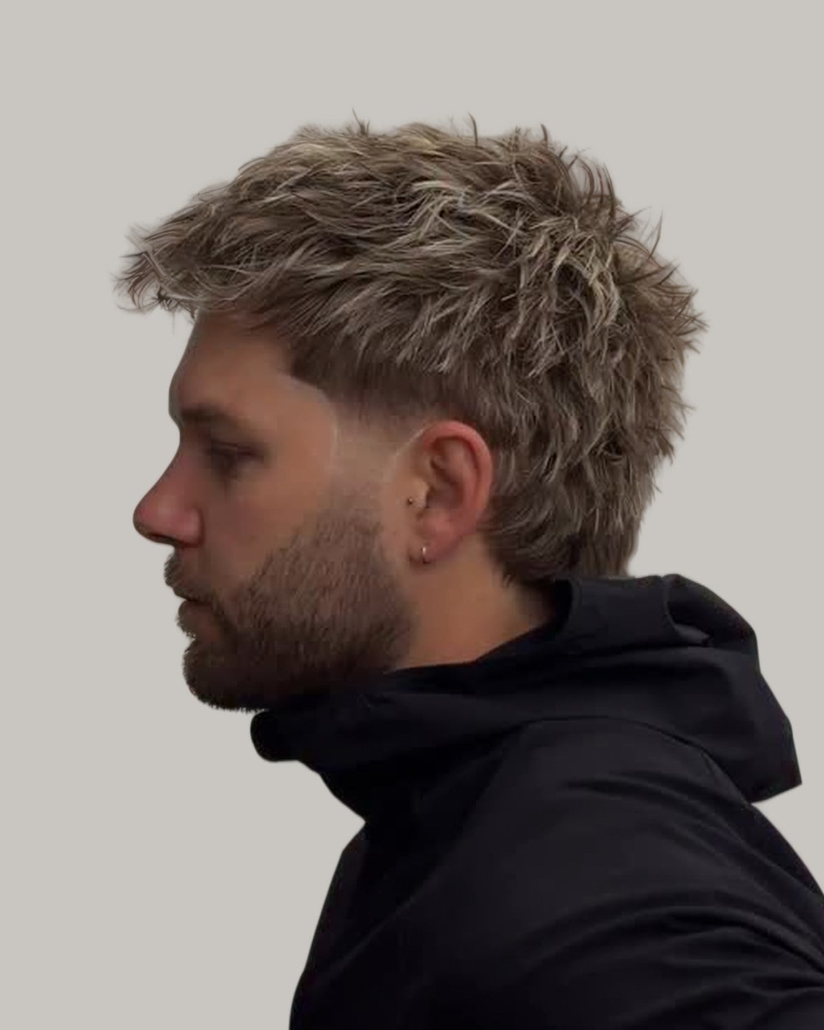 Bearded man with a short textured mullet, seen in profile