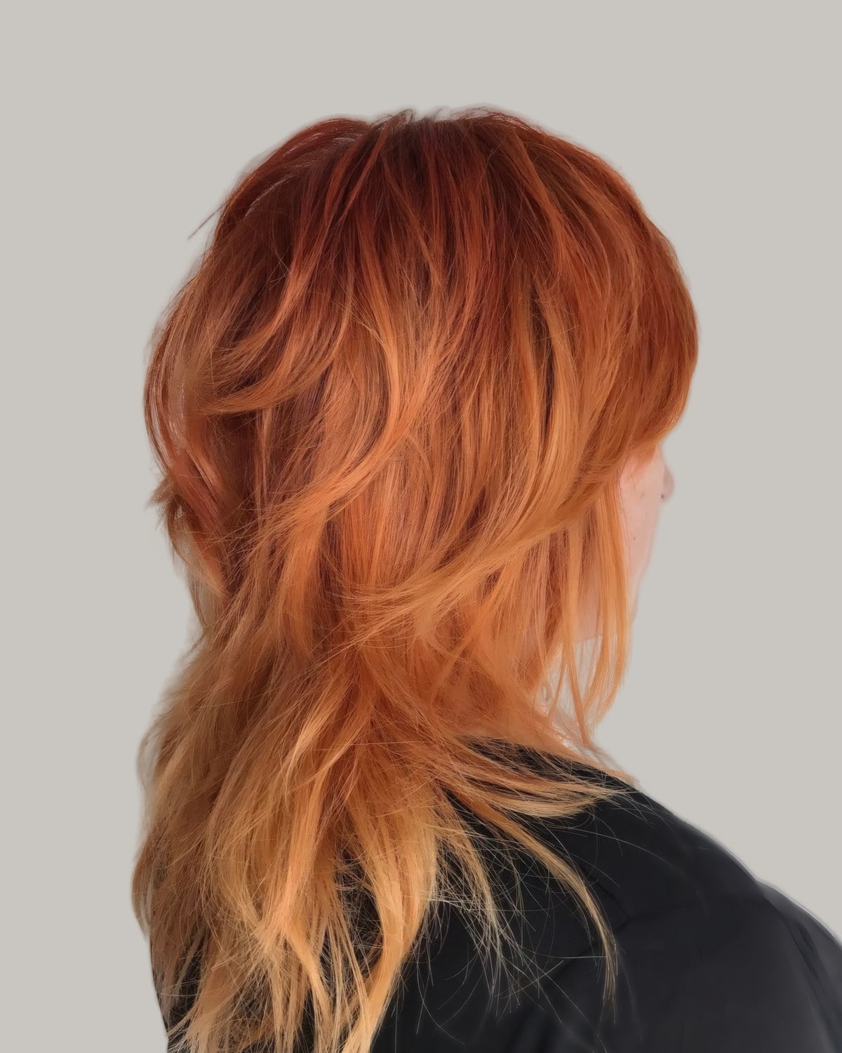 Long copper shag seen from behind and to one side, over a black top