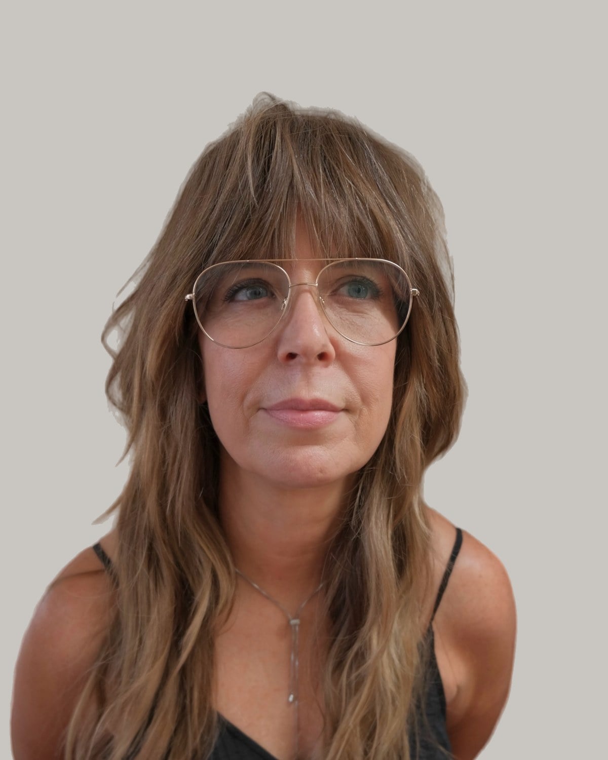 Woman in aviator glasses facing forward, long light brown shag with curtain bangs