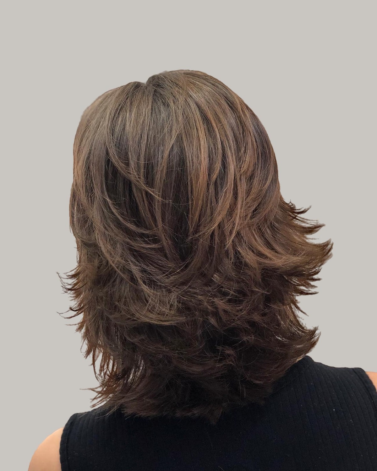 Back view of a medium brunette shag with flicked, layered ends