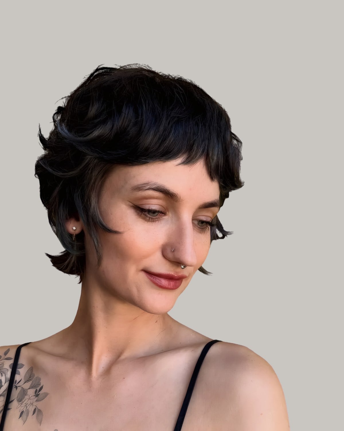 Woman with a short black pixie shag looking down
