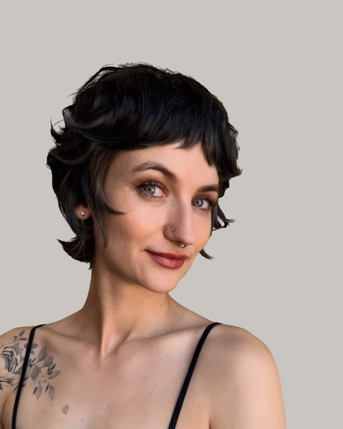 Woman in a black camisole with a short black pixie shag and micro bangs