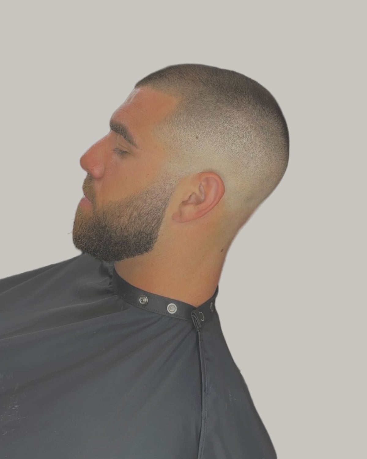 Bearded man with a buzzed top and a bald fade, seen in profile