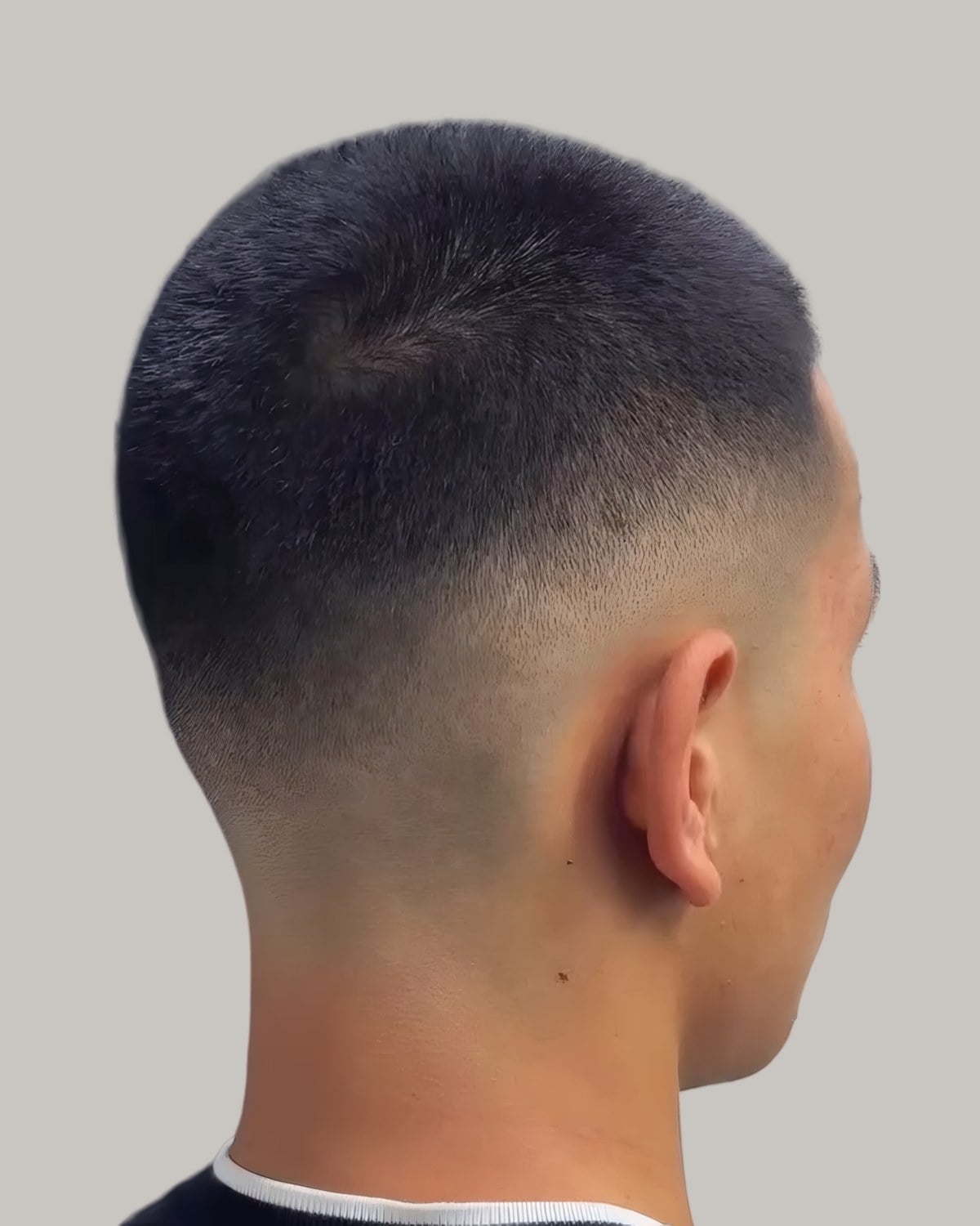 Man with a short Caesar crop and a fade, seen from behind