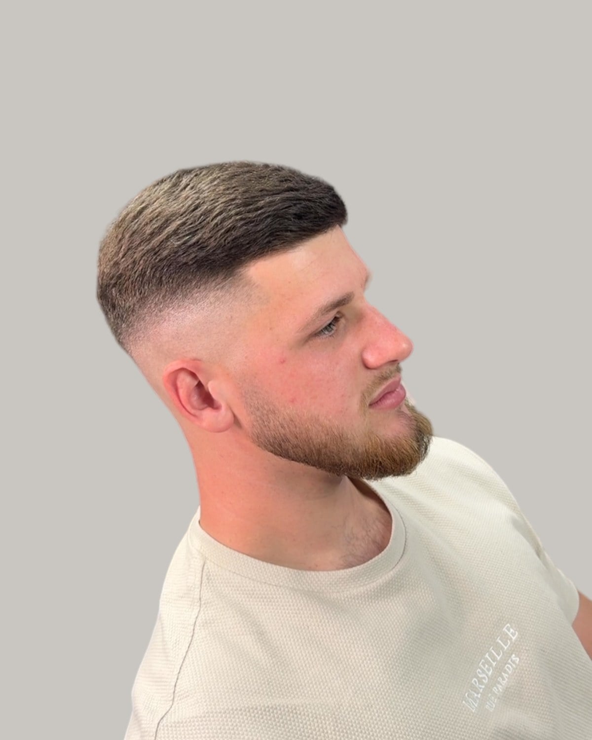 Man with a short crop and a skin fade around the ears, seen in profile
